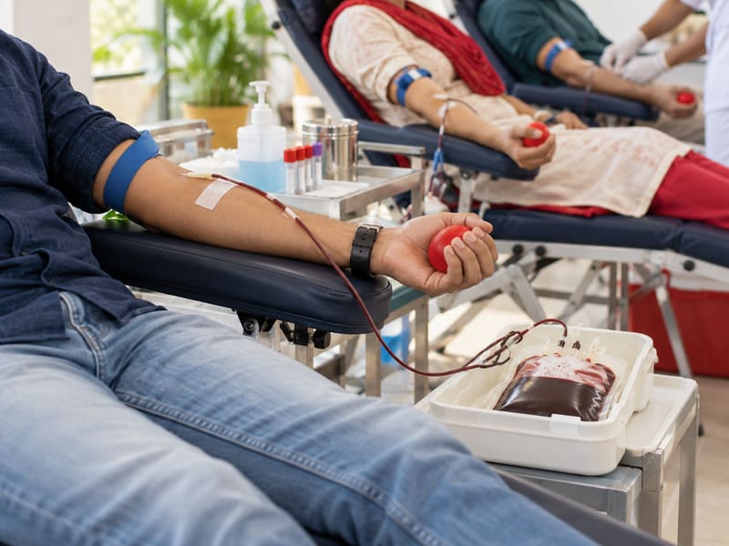 Volunteers donating blood together at a blood donation camp