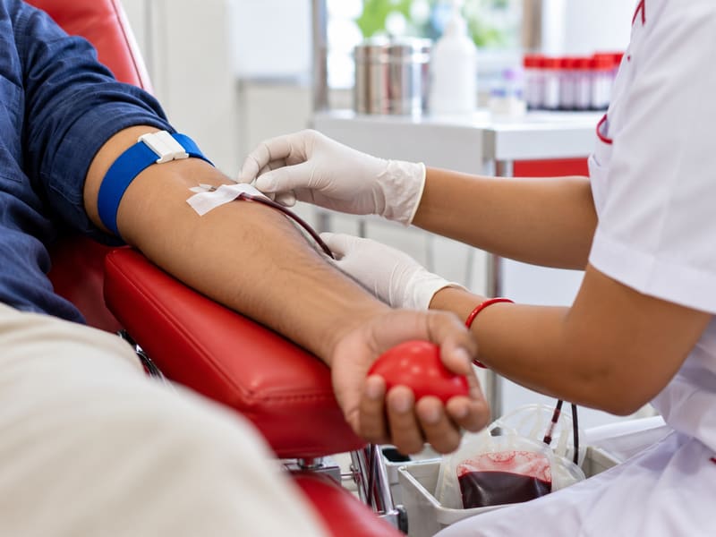 A nurse caring for a blood donor during donation